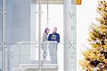 Businessman and woman using digital tablet at balcony