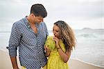 Young couple with coconut milk on Ipanema Beach, Rio de Janeiro, Brazil