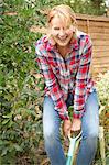 Portrait of mature woman having fun digging garden