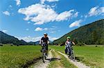 Father and son cycling through Jachenau, Bavaria, Germany