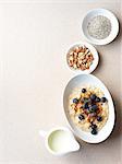 Still life of porridge with fruit and nuts