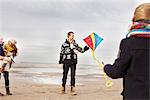Mid adult parents with son and daughter playing with kite on beach, Bloemendaal aan Zee, Netherlands