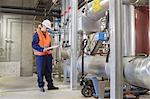 Technician checking paperwork in power station