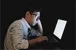 Japanese young businessman working late at his laptop