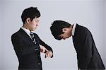 Young Japanese businessman apologizing to his boss