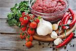 Minced meat, chili pepper, cherry tomato, cilantro and garlic - traditional ingredients of mexican cuisine. Selective focus.