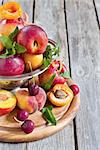 Ripe apricots, nectarines and saturn peaches in steel colander. Selective focus. Copy space background.