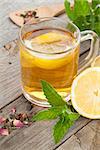 Green tea with lemon and mint on wooden table background