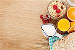 Healty breakfast with muesli, berries and orange juice. View from above on wooden table with copy space