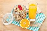 Healty breakfast with muesli, berries and orange juice. View from above on wooden table with copy space