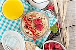 Healty breakfast with muesli, berries and orange juice. On wooden table