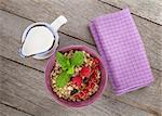 Healty breakfast with muesli, berries and milk. View from above on wooden table