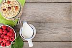 Healty breakfast with muesli, berries and milk. View from above on wooden table with copy space