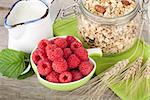 Healty breakfast with muesli, berries and milk. On wooden table