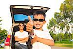 cool boy thumb up and father across arms with car