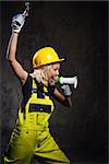 Attractive builder woman shouting through megaphone