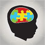 A silhouette of a child with symbolic autism puzzle pieces making the brain space. Vector EPS 10 available.