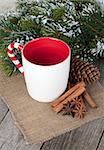 Empty cup for mulled wine, spices and fir tree on wooden table