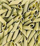 Green colored penne pasta. Food background
