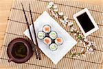 Sushi maki set with salmon and cucumber and green tea. Isolated on white background