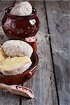 Unpeeled baked potato - potato in jacket - in ceramic pot with pink salt. Selective focus. Copyspace background.