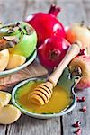 Pomegranate, apple and honey, traditional food of jewish New Year celebration, Rosh Hashana. Selective focus.