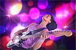 Pretty girl playing guitar against digitally generated cool nightlife design