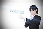 Businesswoman pointing to word issues against white background with vignette