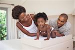Happy parents with their baby girl on changing table at home in the bedroom