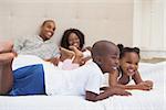 Happy family lying on bed smiling at home in the bedroom