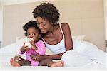 Happy parents with baby girl on their bed at home in the bedroom