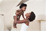 Happy mother with baby girl at home in the bedroom