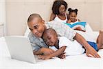 Happy family spending time together on bed at home in the bedroom