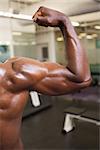 Close up of muscular man flexing muscles in gym