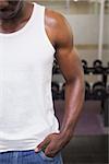 Close-up mid section of a cropped muscular man standing in gym