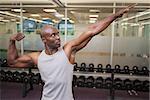 Portrait of a young muscular man posing in gym