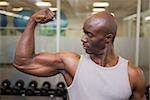 Portrait of a muscular man flexing muscles in gym