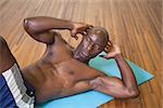 High angle view of muscular man doing abdominal crunches in gym