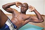 Portrait of a muscular man doing abdominal crunches in gym