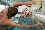 Female fitness class doing aqua aerobics with male instructor in swimming pool at the leisure centre