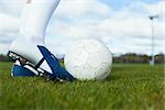 Football player about to kick ball on a clear day