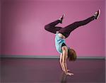 Pretty break dancer doing a handstand in the dance studio