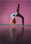 Pretty break dancer bending backwards with leg up in the dance studio