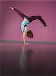 Pretty break dancer doing handstand in the dance studio