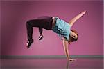 Pretty break dancer doing a handstand in the dance studio