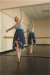 Beautiful ballerina dancing in front of mirror in the dance studio