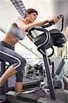 Fit woman working out on the exercise bike at the gym