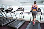 Fit brunette running on the treadmill at the gym