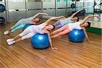 Fitness class on exercise balls in studio at the gym