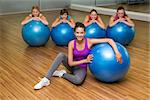 Fitness class posing with exercise balls in studio at the gym